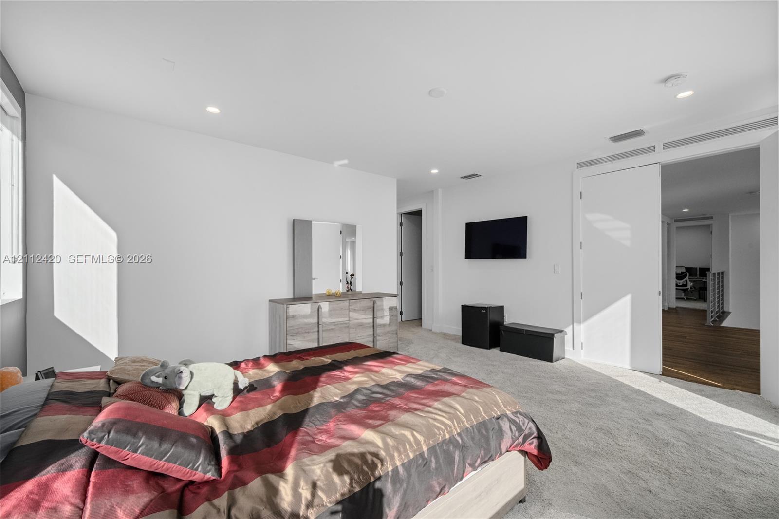 Neutral interior featuring recessed lighting, wall-to-wall carpeting, and a large-scale sliding door