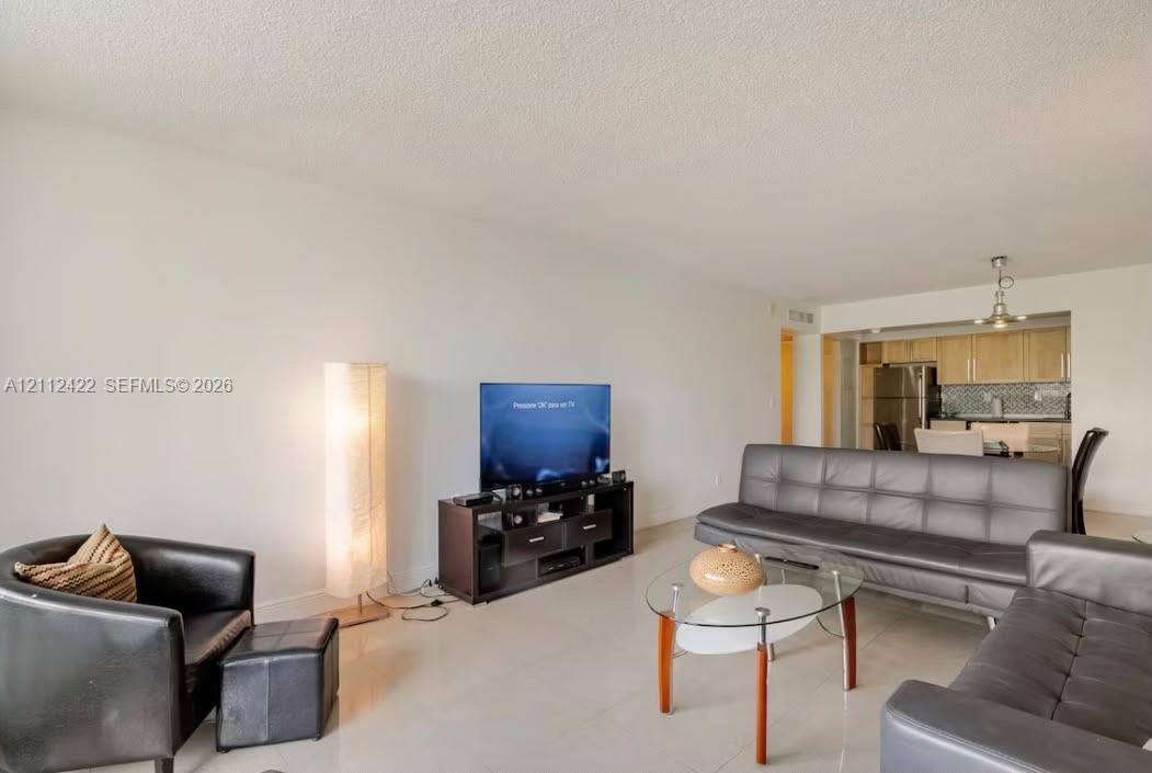 Open-concept interior featuring light-colored tile flooring and a neutral color palette