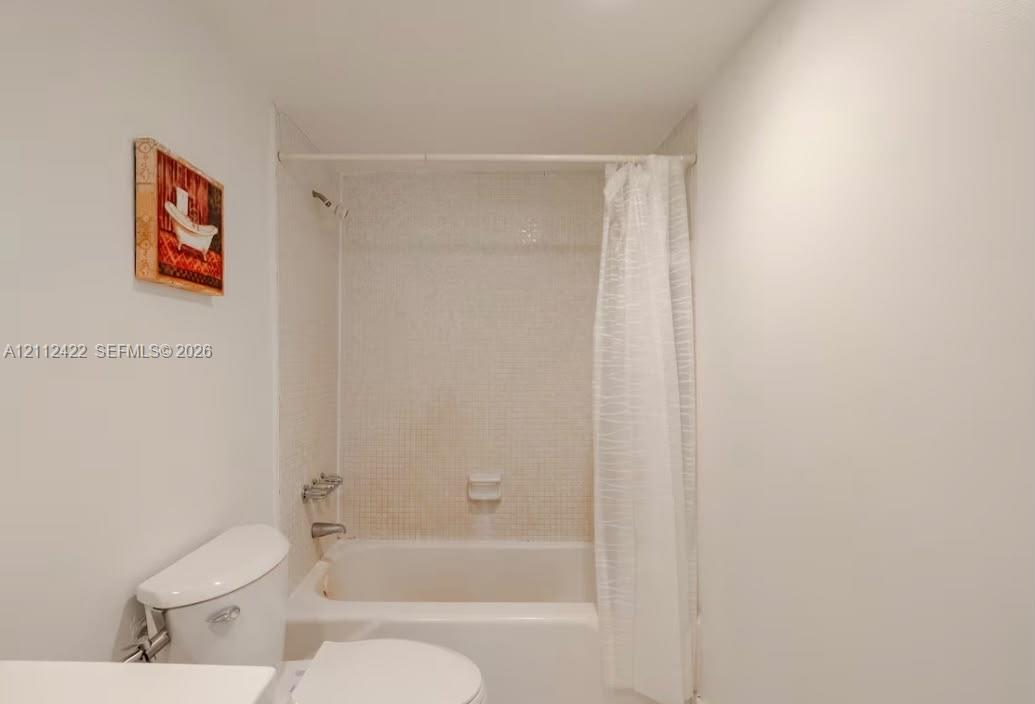 Bathtub featuring light-toned mosaic wall tile surround and chrome plumbing fixtures