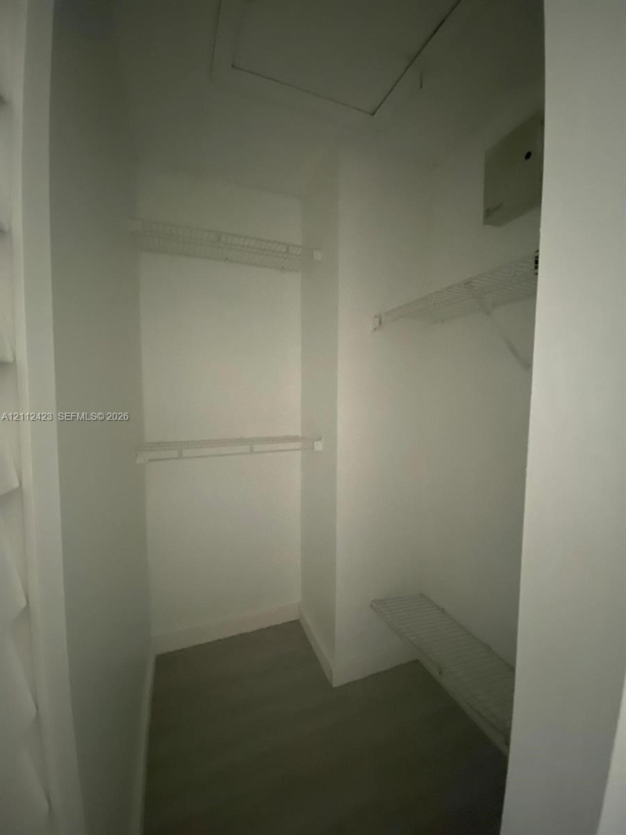 Storage area featuring wire shelving and wood-finish flooring