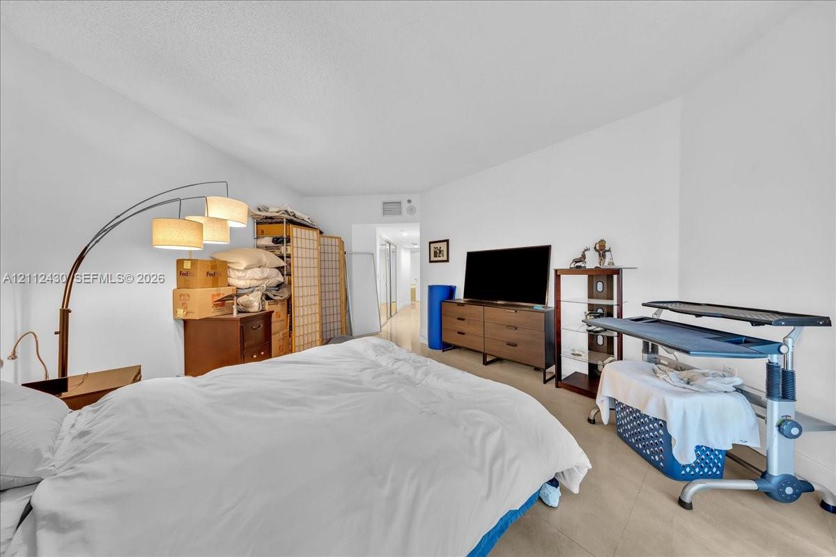 Room interior featuring neutral wall paint, smooth-finish ceiling, and large-format tile flooring