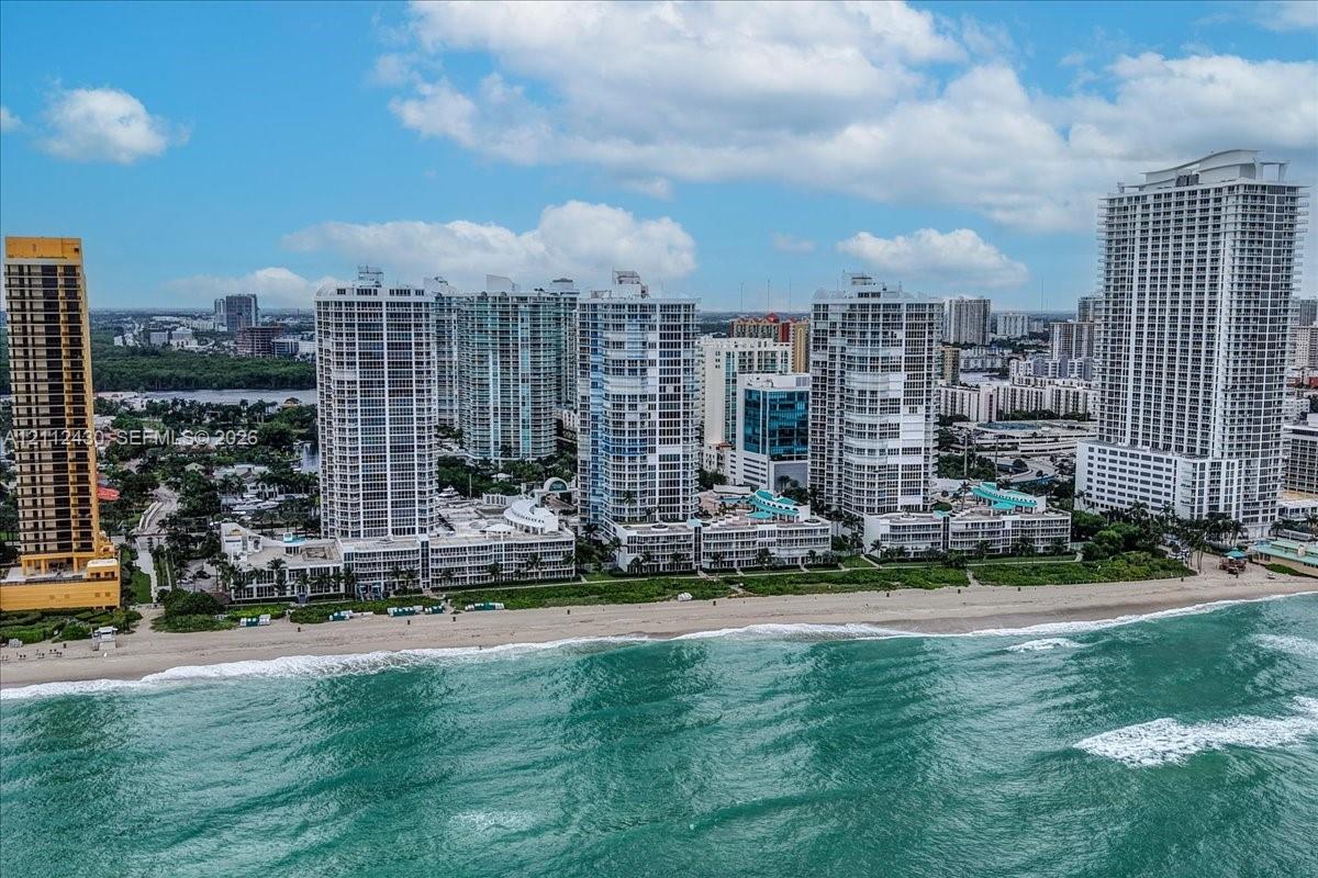 High-rise residential towers positioned directly along the Atlantic coastline, featuring expansive sandy beaches, oceanfront access, and proximity to coastal vegetation