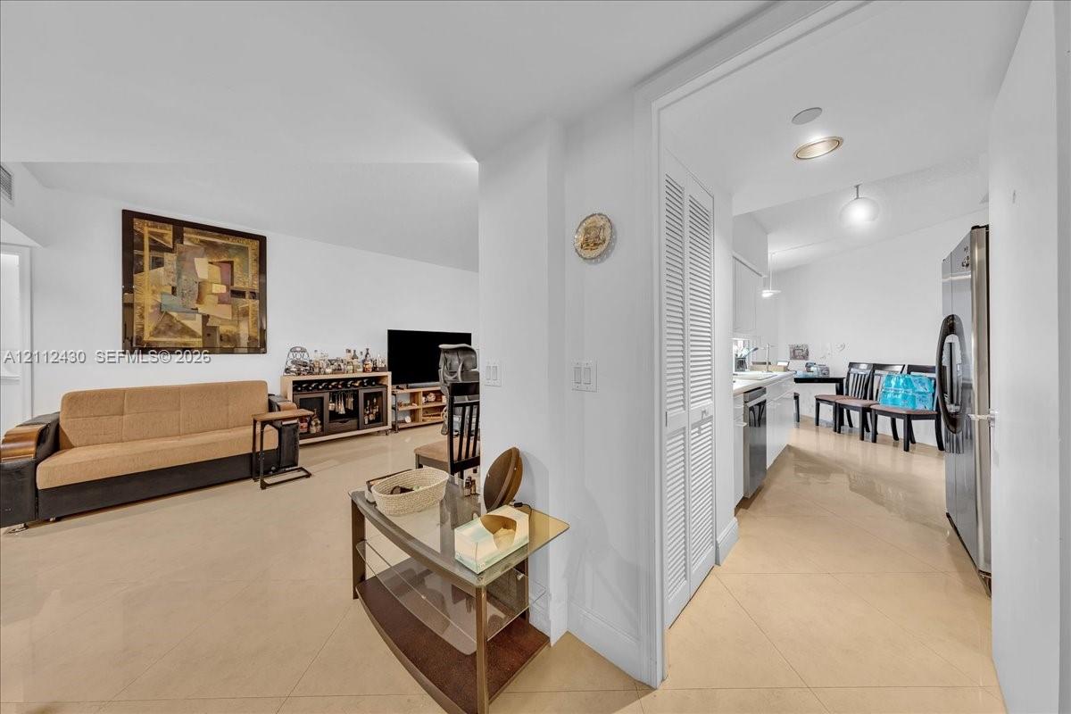 Large-format tile flooring, recessed ceiling lighting, and built-in louvered-door closet Large-format tile flooring, recessed ceiling lighting, and built-in louvered-door closet