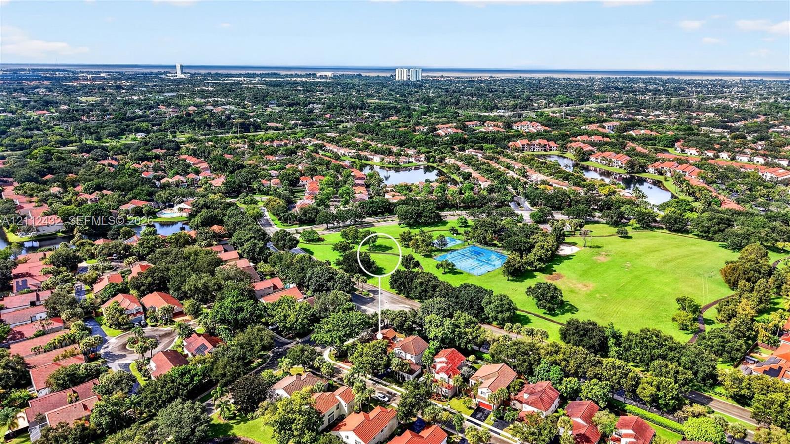Aerial perspective featuring mature trees, expansive green space, and proximity to water elements