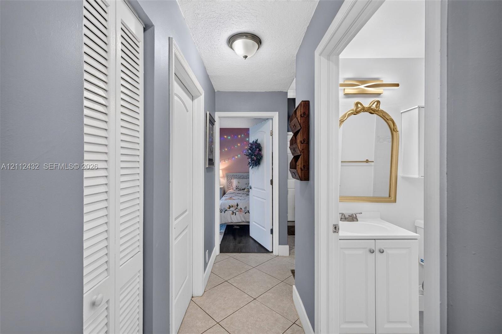 Hallway featuring diagonal tile flooring, multi-panel interior doors, and closet with louvered doors