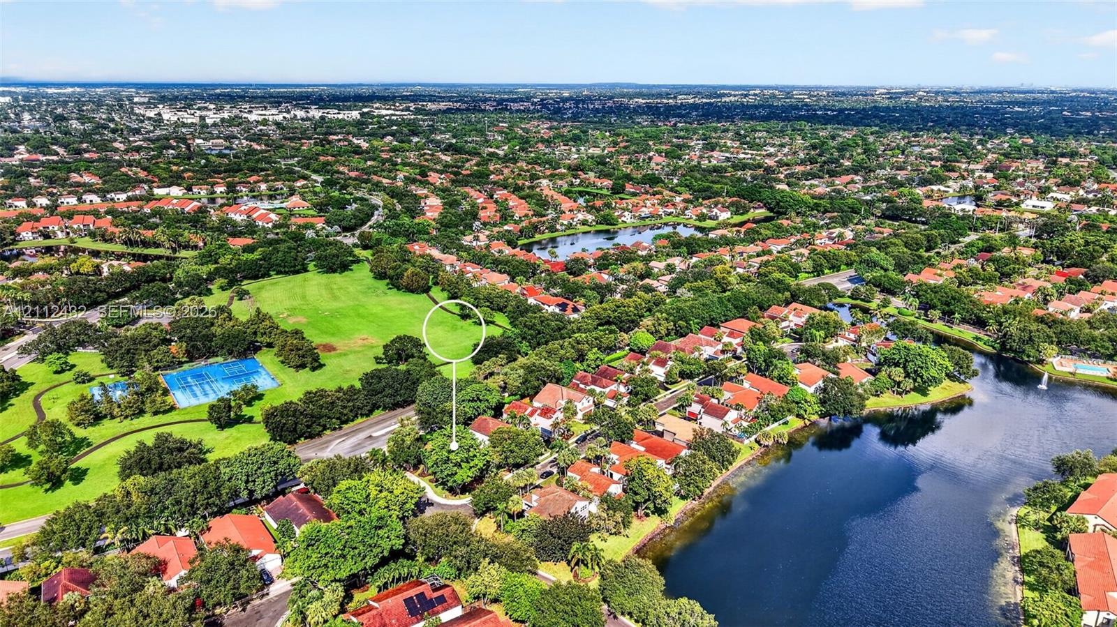 Aerial perspective of a lot featuring mature trees, positioned near community green space and water features