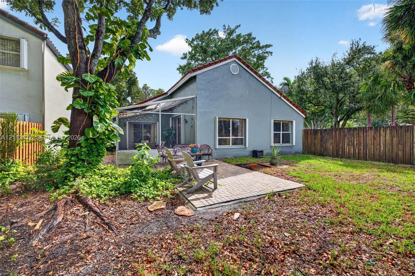 Backyard featuring a paved patio, screened enclosure