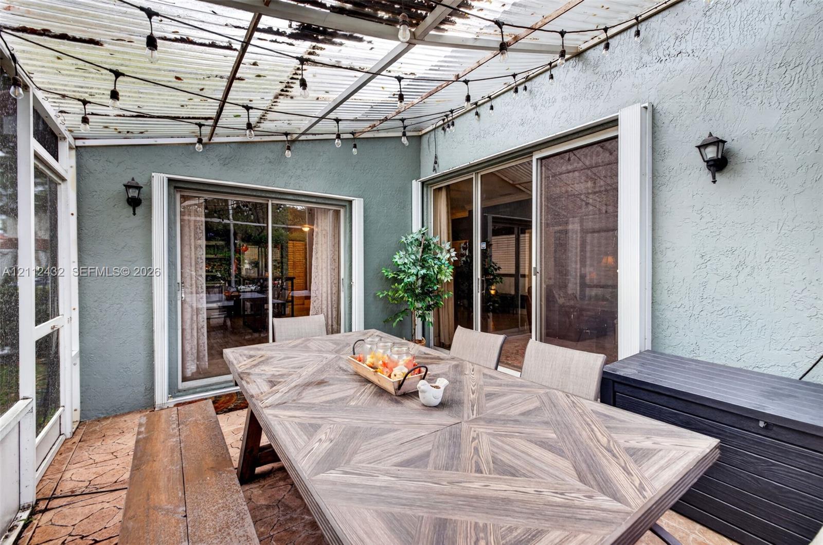 Covered patio featuring a corrugated roof, and dual sliding glass doors