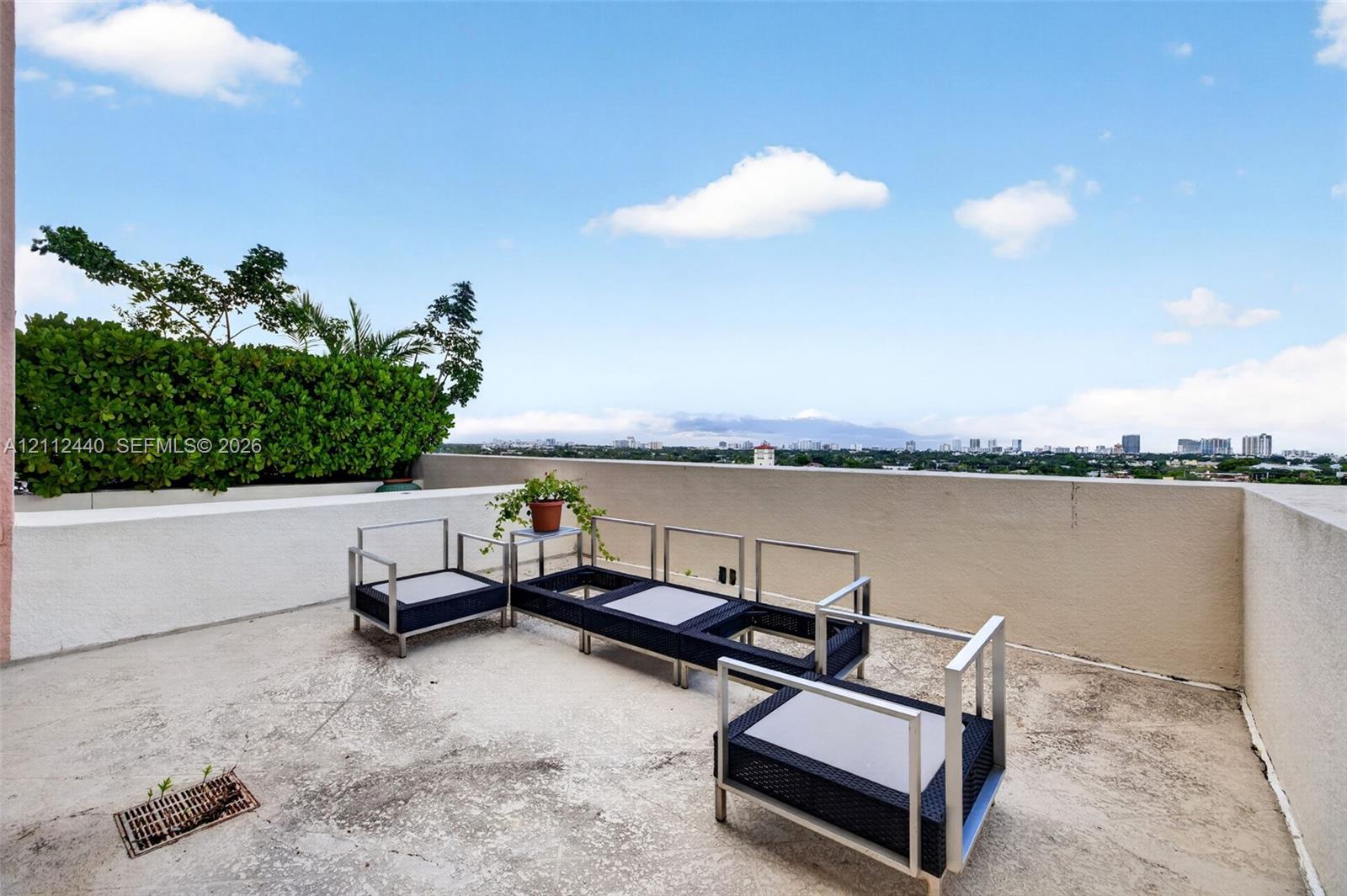 Expansive terrace featuring concrete flooring, solid masonry perimeter walls, and built-in landscape planter hedging
