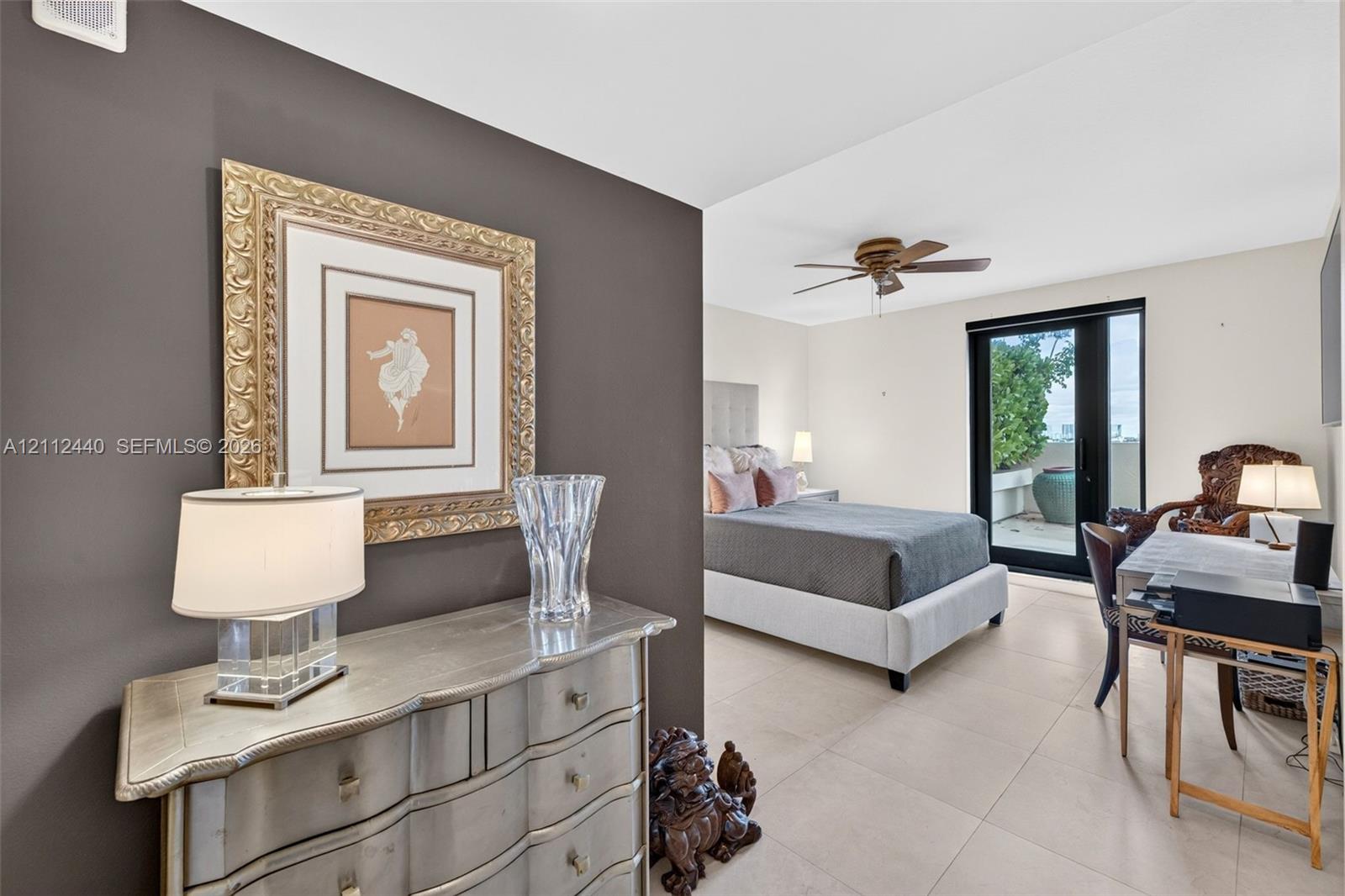 Large-format porcelain flooring, ceiling fan with integrated lighting, and glass-paned exterior door with access to private balcony