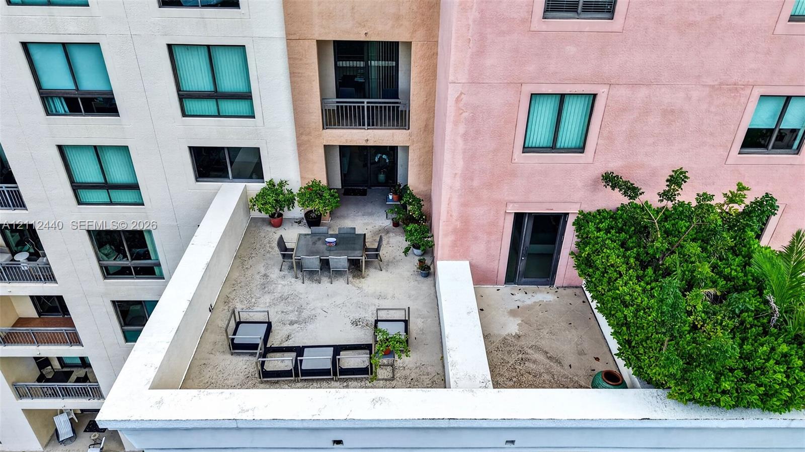Elevated terrace featuring a concrete surface, built-in structural retaining walls, and mature landscaping