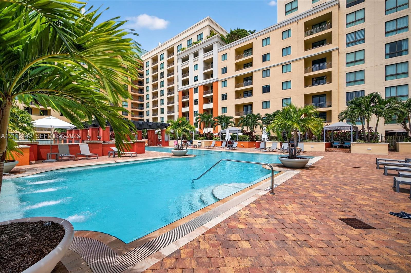 Swimming pool featuring a sun shelf entry, decorative water fountains, paver patio surround, and integrated planters