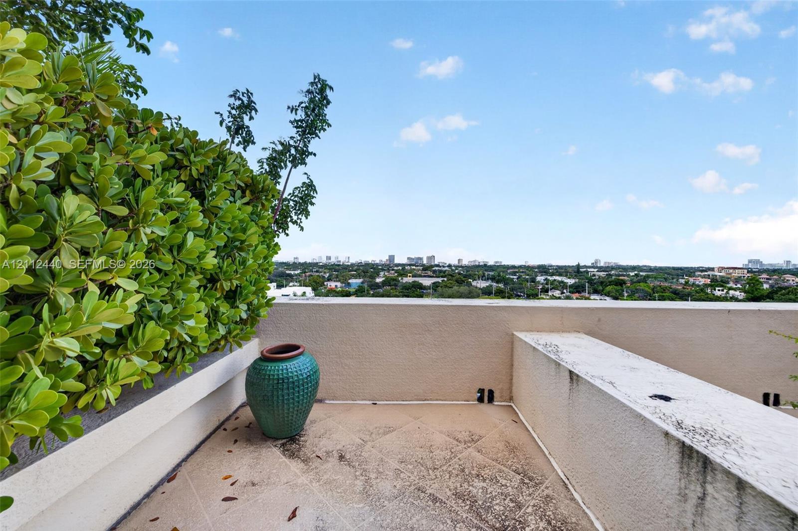 Primary bedroom oversized terrace featuring concrete flooring, built-in planter boxes, and stucco perimeter walls