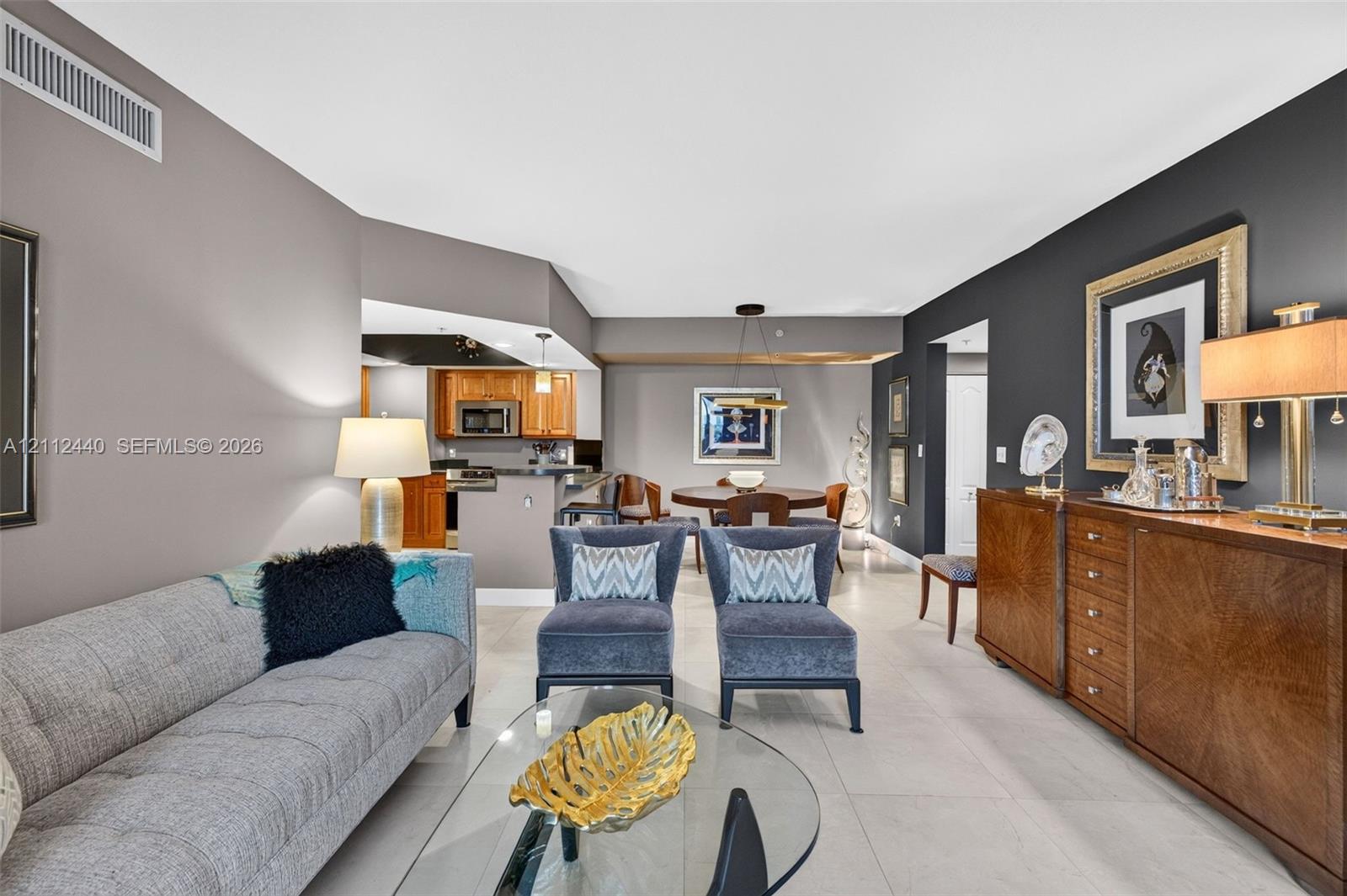 Living area featuring neutral porcelain flooring and a dark accent wall