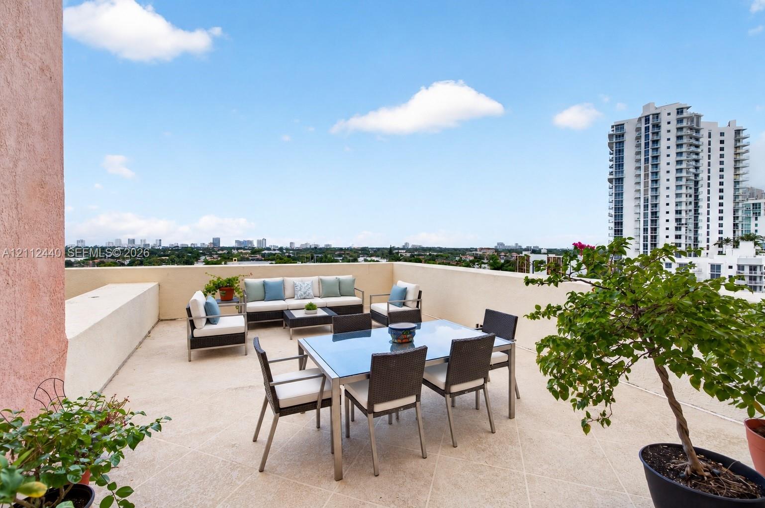Expansive rooftop terrace featuring solid masonry perimeter walls and textured tile flooring