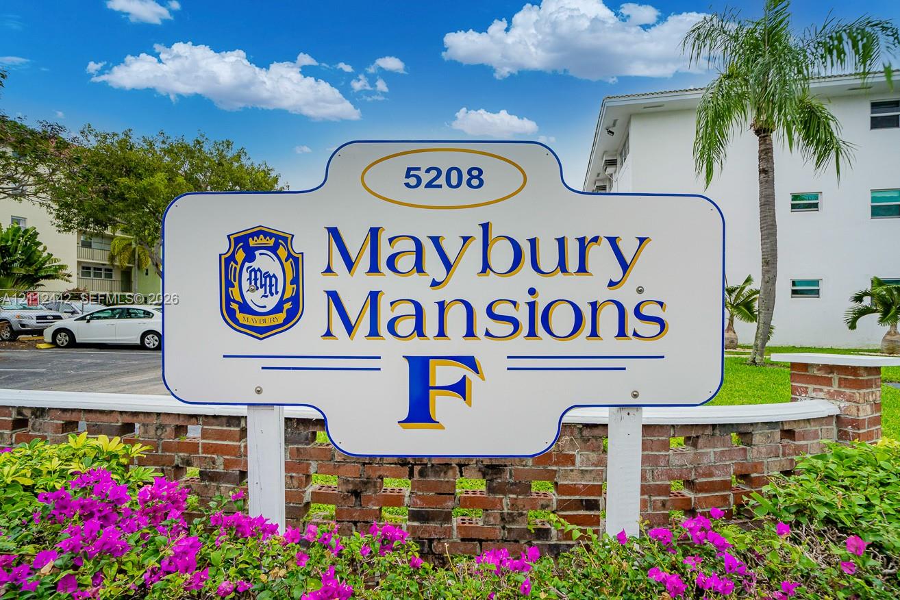 Custom property signage for Maybury Mansions featuring a brick masonry wall and mature tropical landscaping