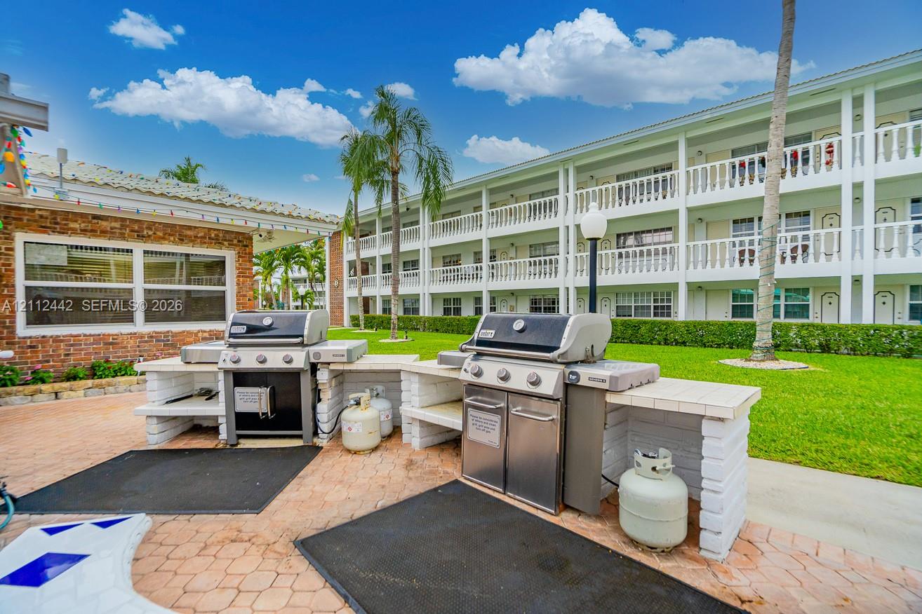 Outdoor grilling area featuring two stainless steel gas grills, built-in masonry counters, and paver patio flooring