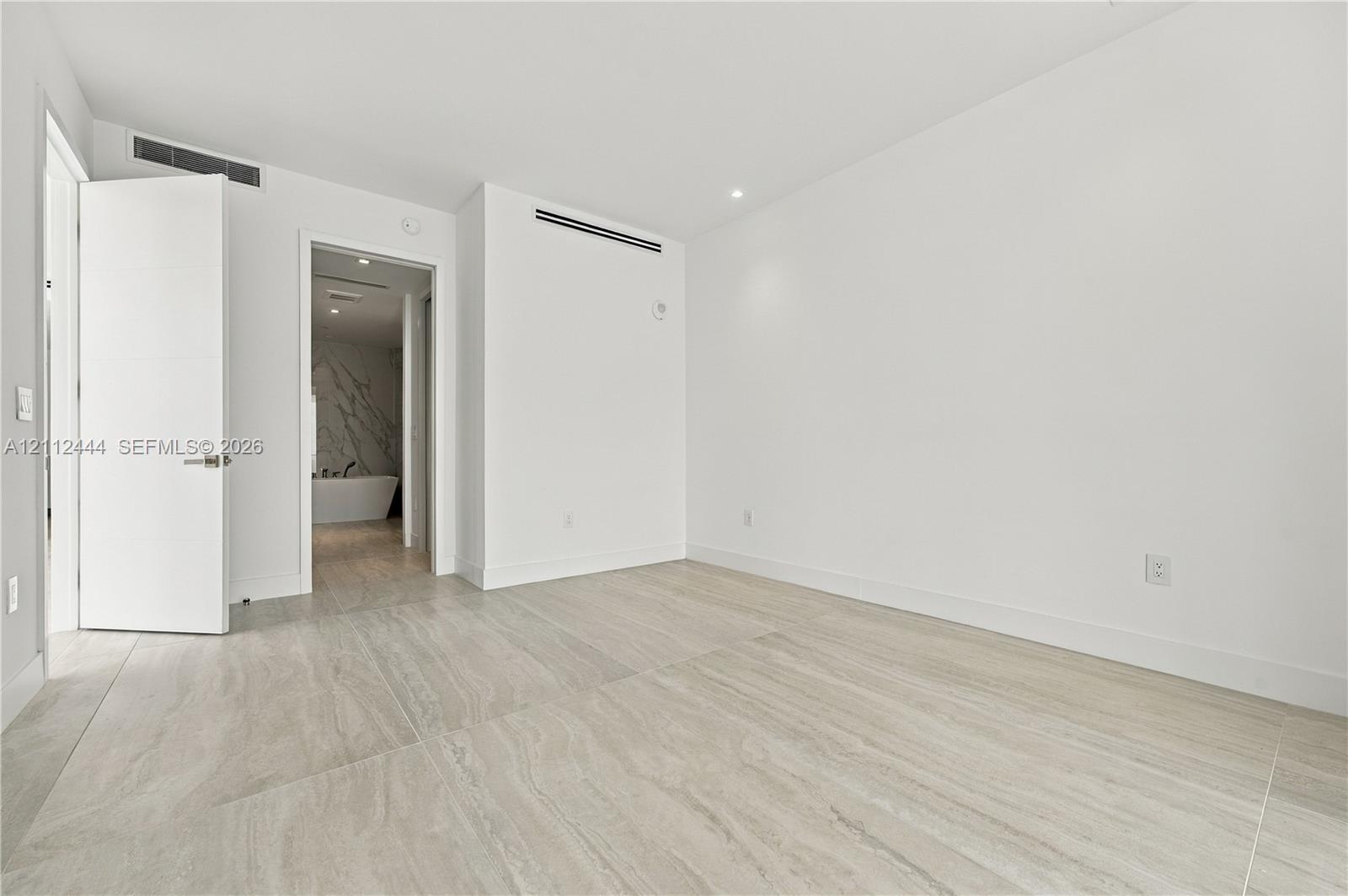 Large-format tile flooring, recessed ceiling lighting, and solid-core doors