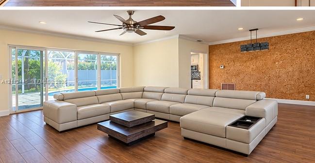 Living area featuring wood-finish flooring, a textured accent wall, recessed lighting, a ceiling fan, and large sliding glass doors Living area featuring wood-finish flooring, a textured accent wall, recessed lighting, a ceiling fan, and large sliding glass doors