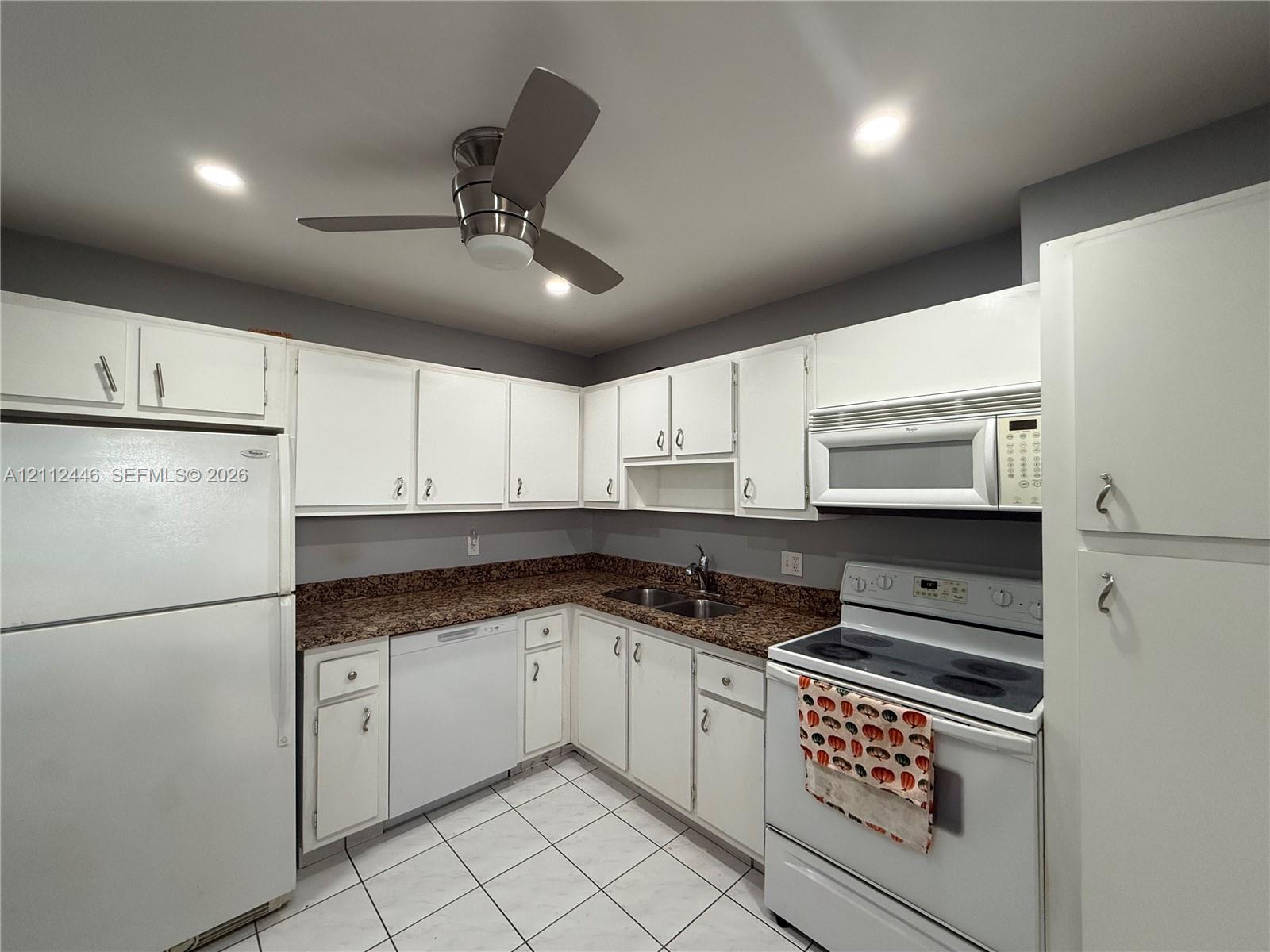 Kitchen featuring white cabinetry, speckled stone countertops, tiled flooring, recessed lighting, and a ceiling fan Kitchen featuring white cabinetry, speckled stone countertops, tiled flooring, recessed lighting, and a ceiling fan