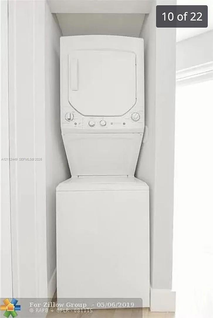 White stacked laundry unit contained within a recessed alcove