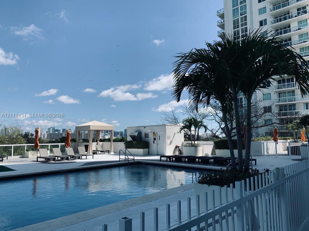Outdoor swimming pool with surrounding sun deck, built-in cabana, and integrated landscaping