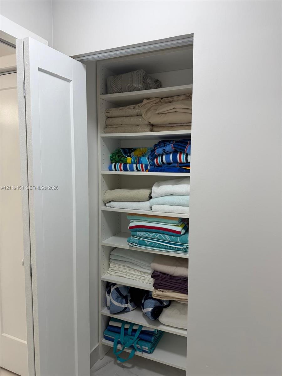 Built-in recessed shelving unit featuring adjustable white cabinetry and a solid-core swing door