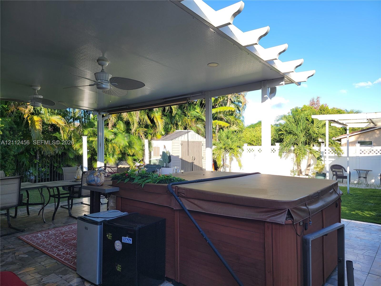 Covered patio featuring a white pergola, recessed lighting, dual ceiling fans, and paver flooring