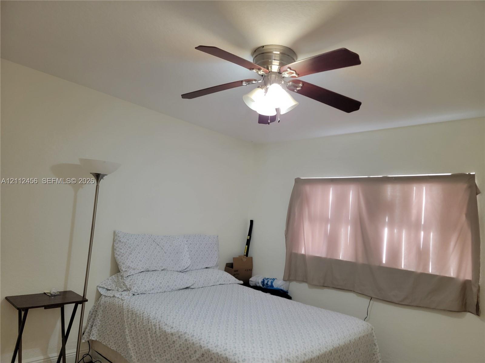Ceiling-mounted fan featuring a metallic finish and multi-blade configuration with an integrated three-light fixture