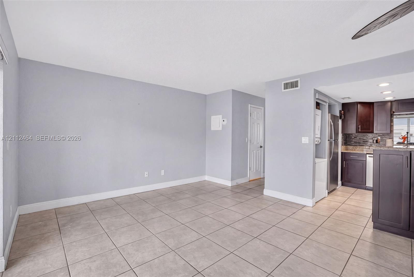 Interior space featuring ceramic tile flooring, dark-toned cabinetry, stainless steel appliances, and stone-finish countertops Interior space featuring ceramic tile flooring, dark-toned cabinetry, stainless steel appliances, and stone-finish countertops