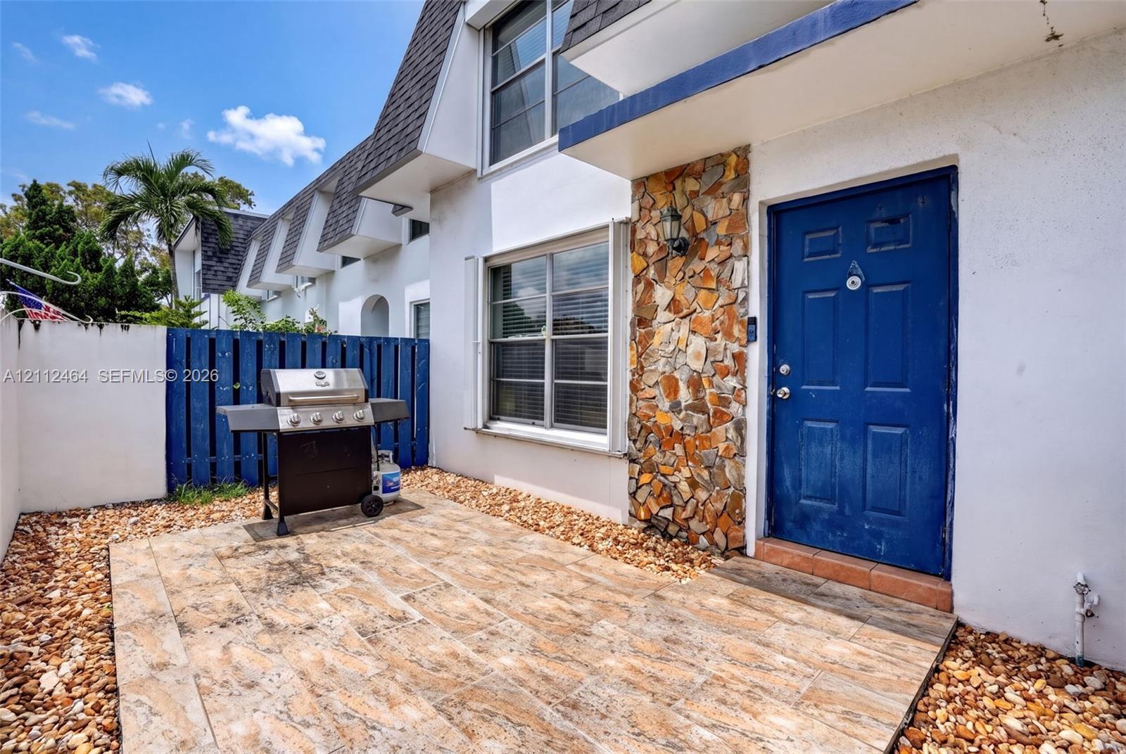 Private courtyard featuring tile hardscaping, decorative stone exterior accents, and perimeter fencing Private courtyard featuring tile hardscaping, decorative stone exterior accents, and perimeter fencing
