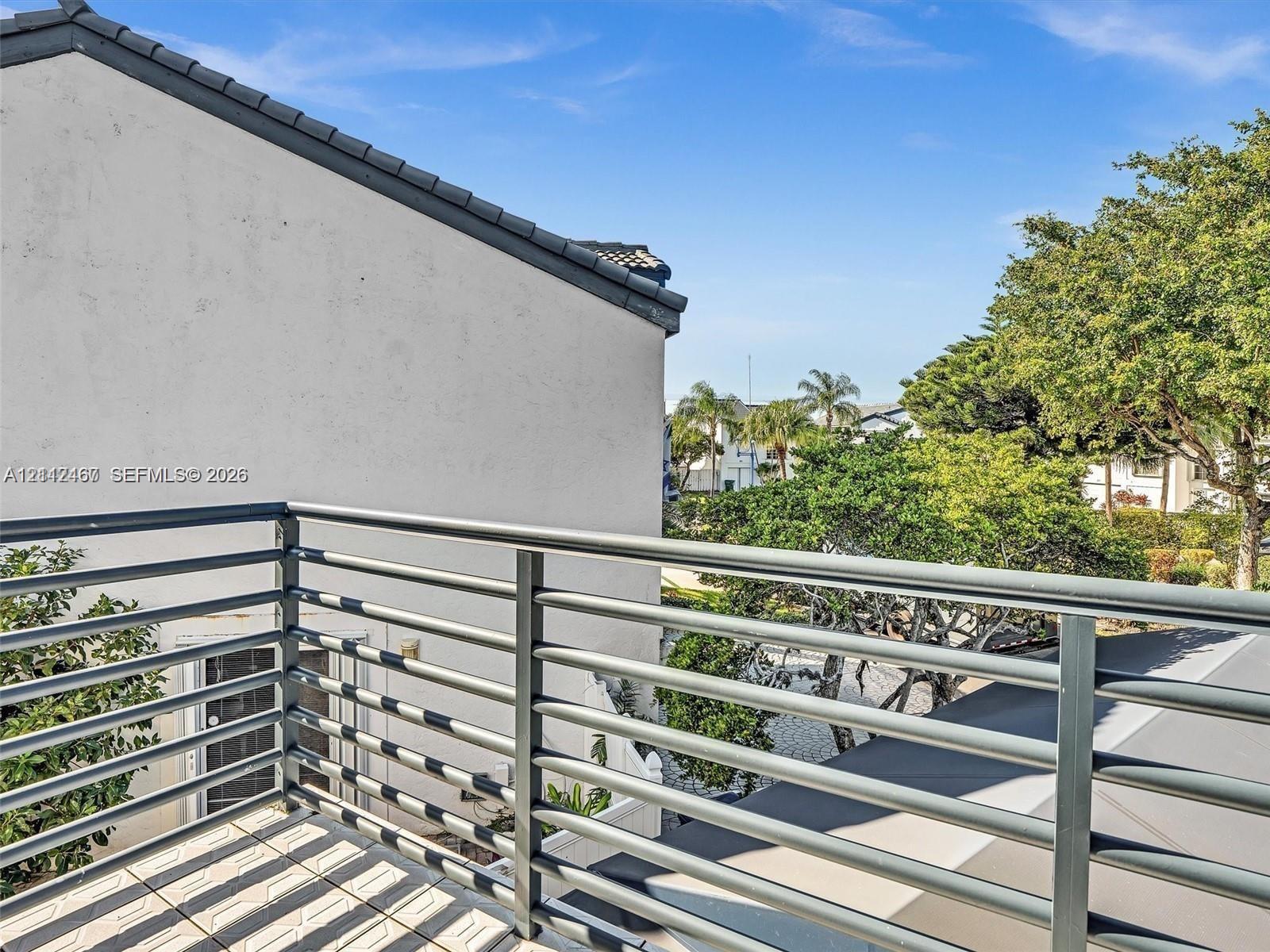 Elevated balcony featuring a metal horizontal-bar railing and tiled flooring