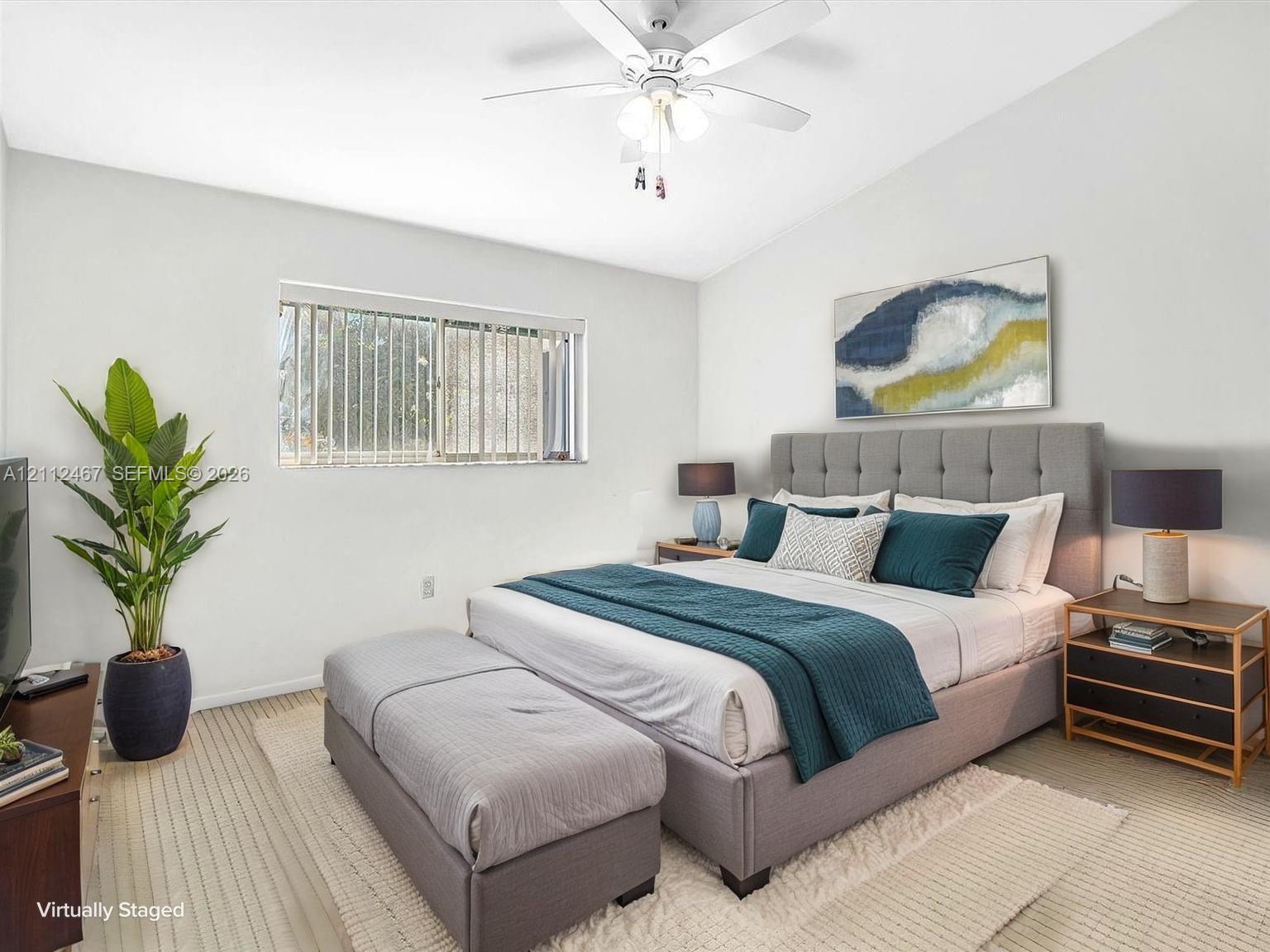 Bedroom featuring a vaulted ceiling, ceiling fan with integrated lighting, neutral wall-to-wall carpeting, and a large horizontal sliding window