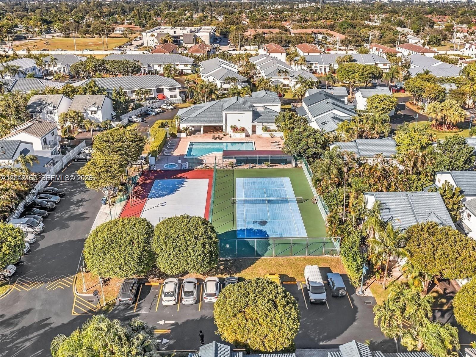 Community recreation area featuring a swimming pool, spa, fenced tennis court, and multi-purpose sports court
