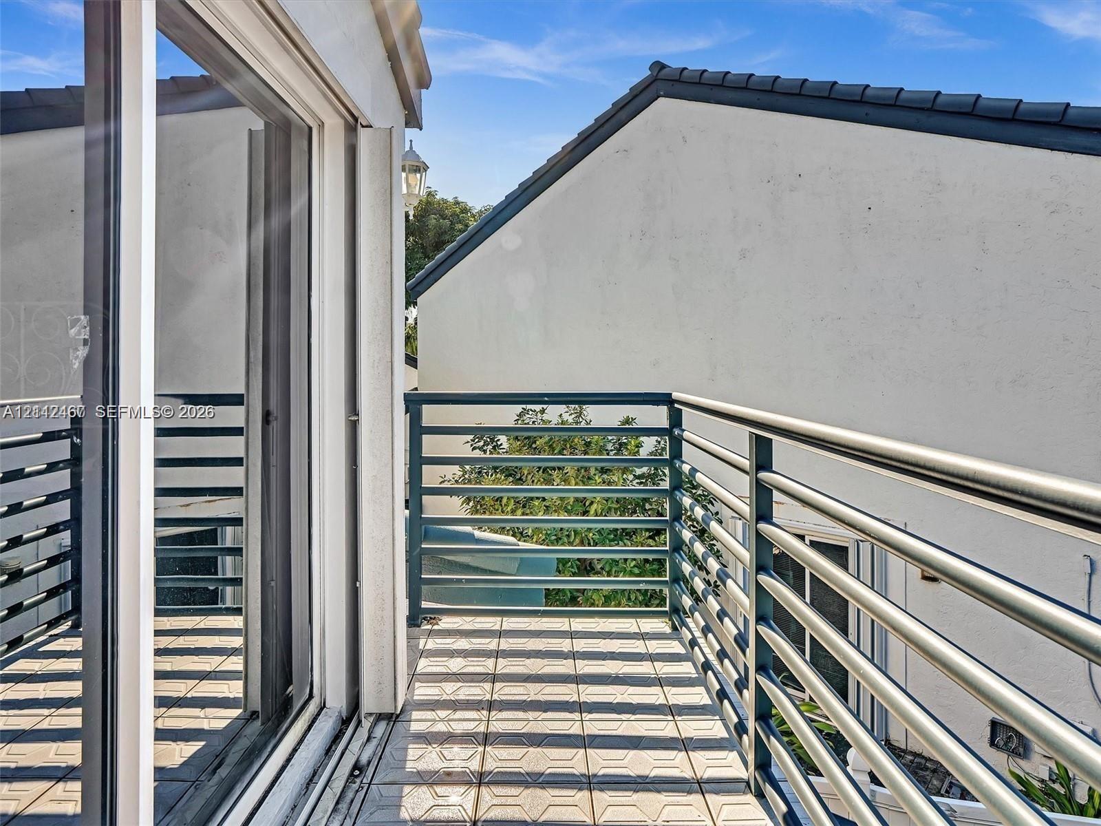 Balcony featuring square tile flooring and horizontal metal railings