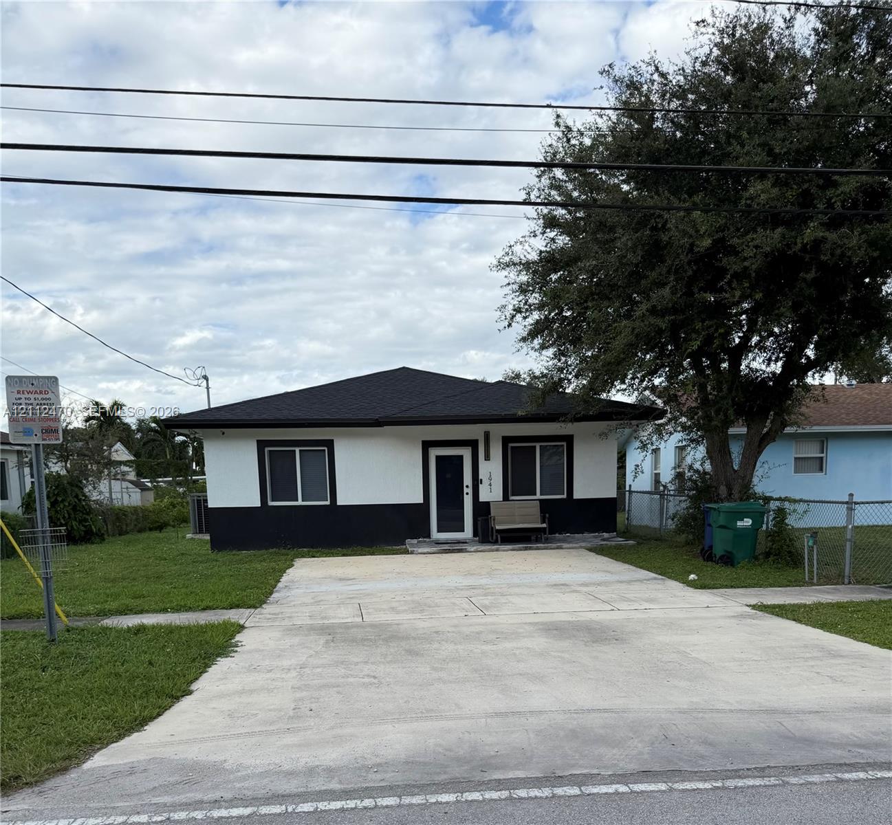Single-story exterior featuring two-tone smooth stucco siding, a hipped roofline, and a concrete driveway