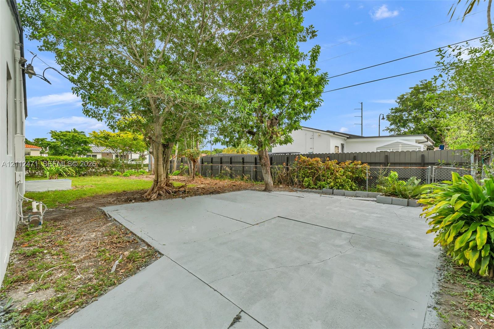 Concrete patio, fenced perimeter, mature trees, and landscaped green space Concrete patio, fenced perimeter, mature trees, and landscaped green space