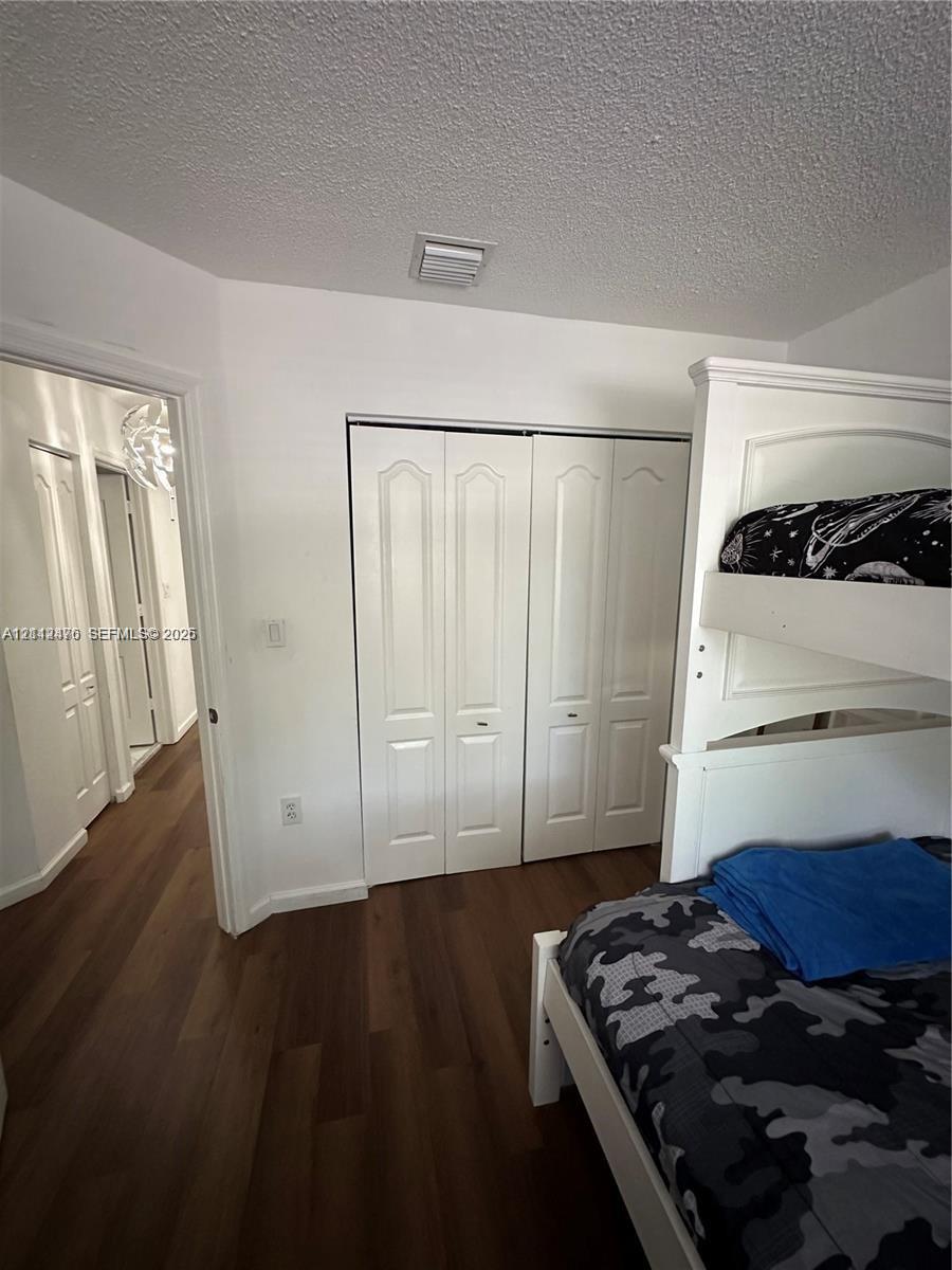 Wood-finish flooring and white bi-fold closet doors