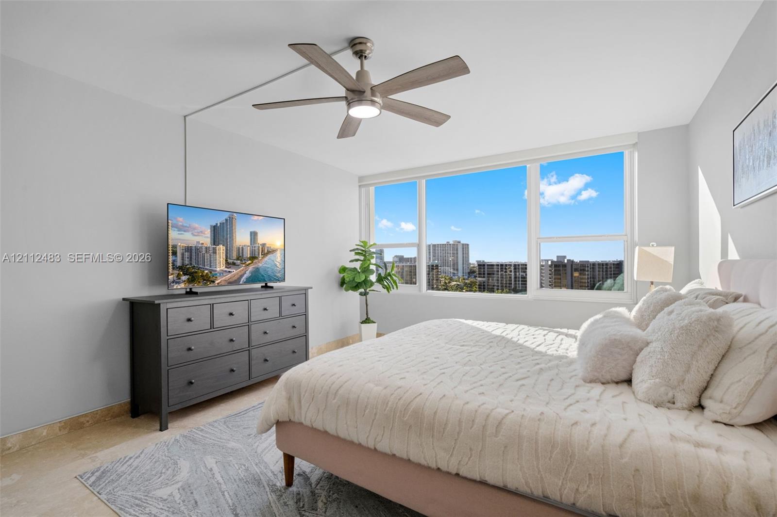 Large-format picture windows, stone-finish flooring, and a multi-blade ceiling fan with integrated lighting