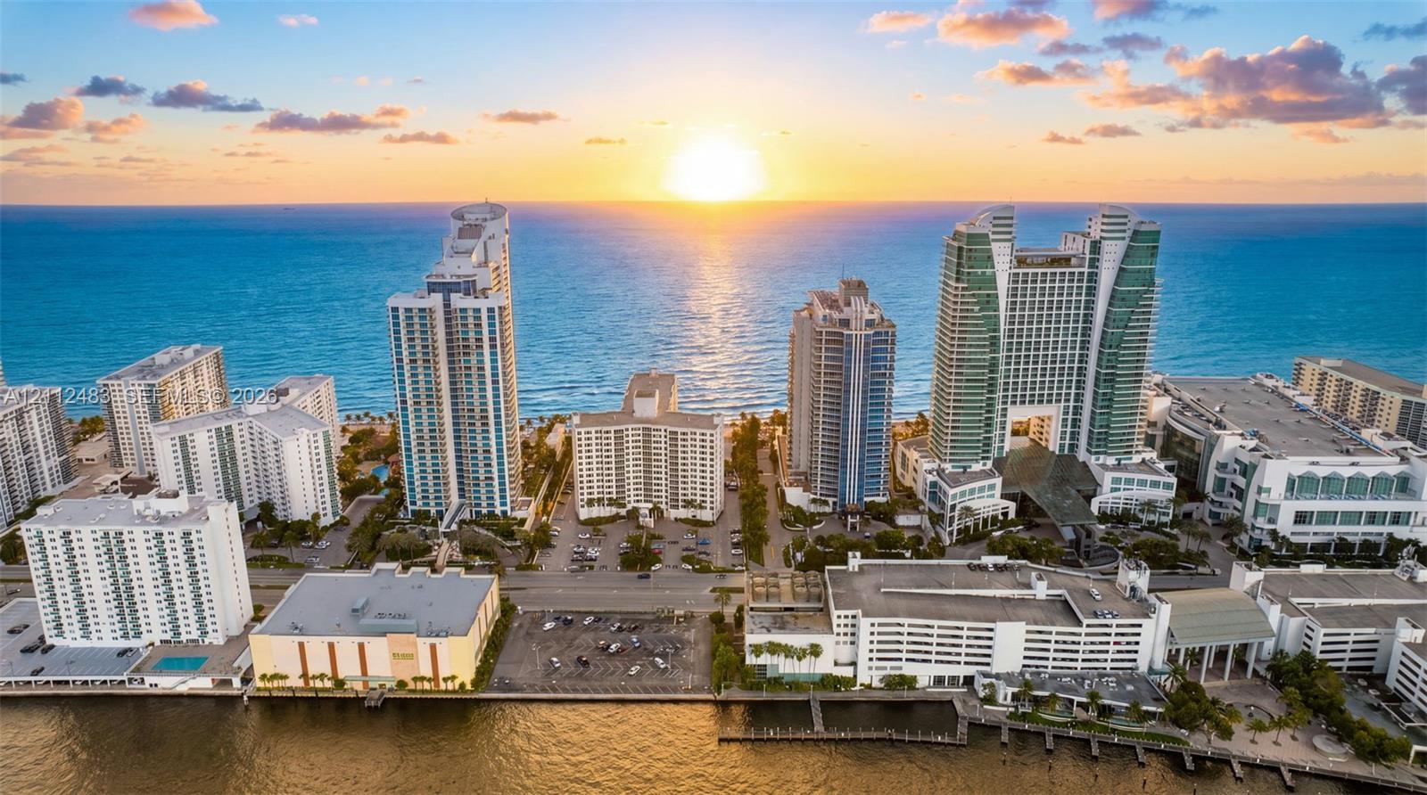 Aerial coastal perspective featuring oceanfront high-rise structures, waterfront access, and expansive water horizon