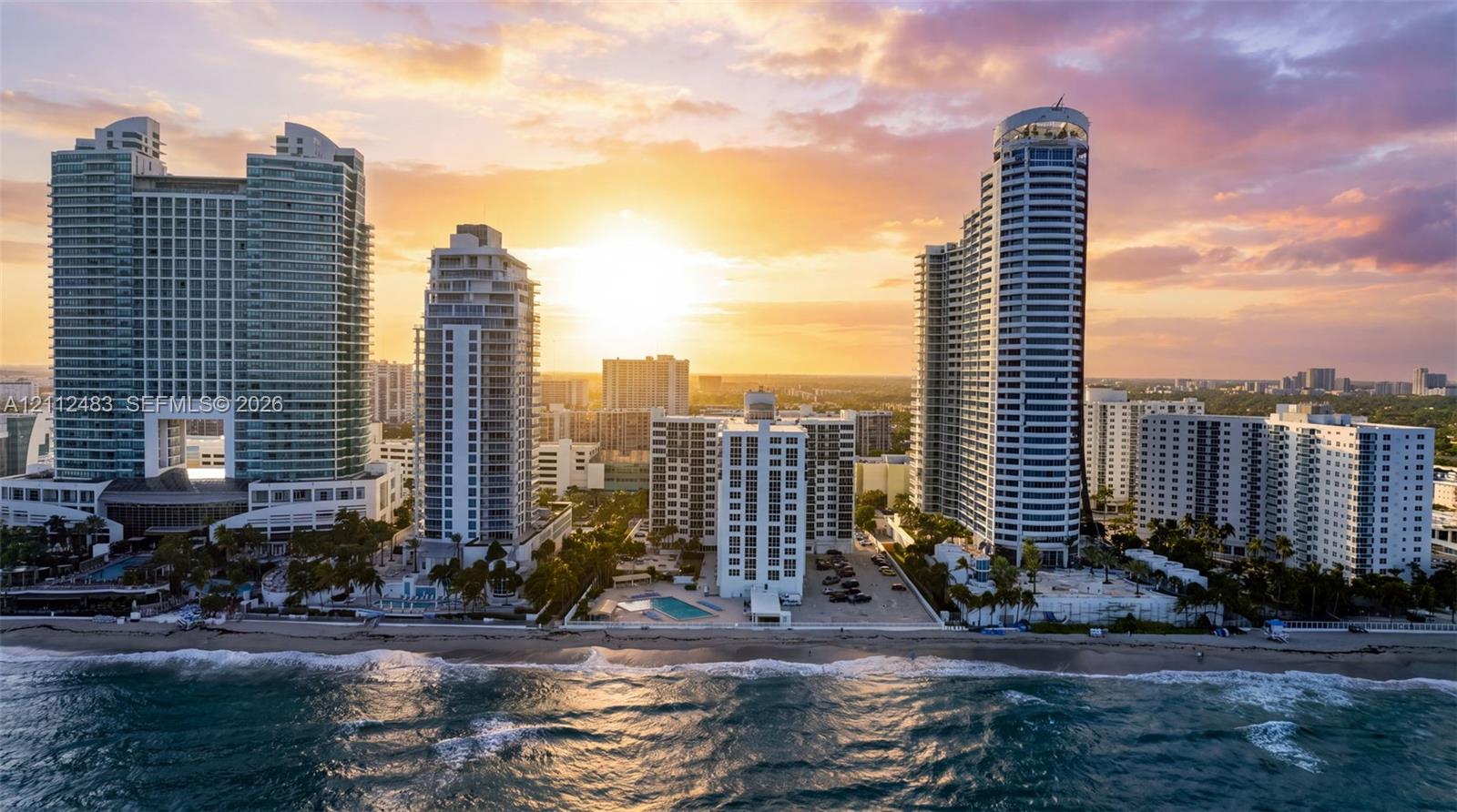 High-rise coastal development featuring glass-facade towers, direct beachfront access, and private outdoor swimming pools