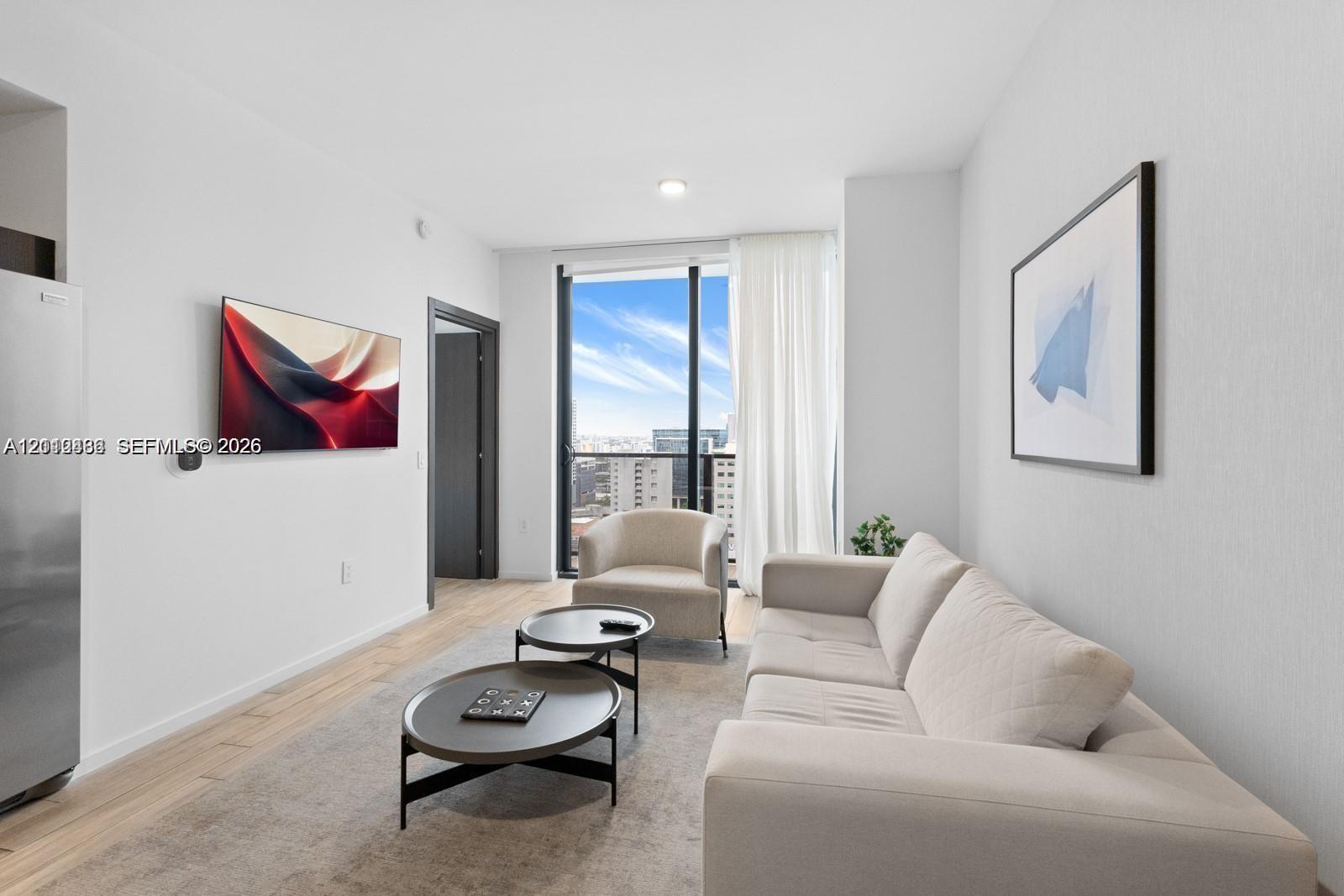 Living area featuring floor-to-ceiling windows, wood-finish flooring, and recessed ceiling lighting