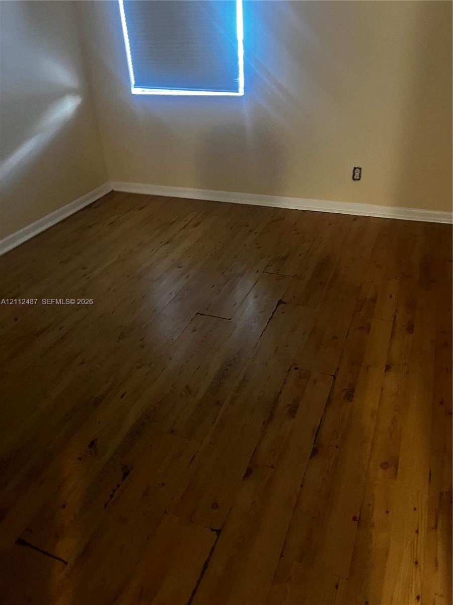 Wood-finish flooring and a window featuring a roller shade Wood-finish flooring and a window featuring a roller shade