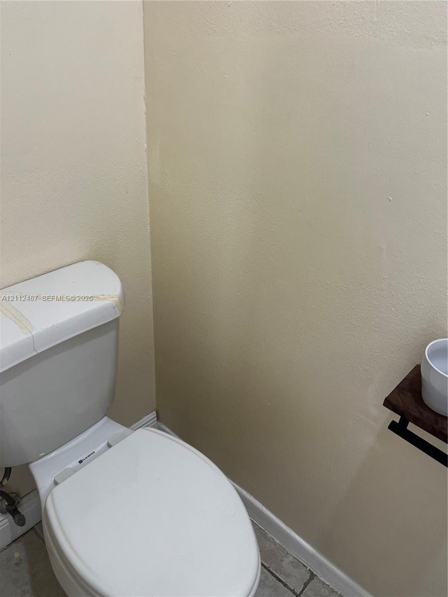 White porcelain toilet and wall-mounted wooden shelf fixture White porcelain toilet and wall-mounted wooden shelf fixture