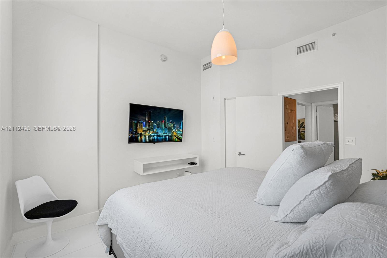 Wall-mounted white shelving, suspended dome pendant lighting, and smooth-finish white interior walls