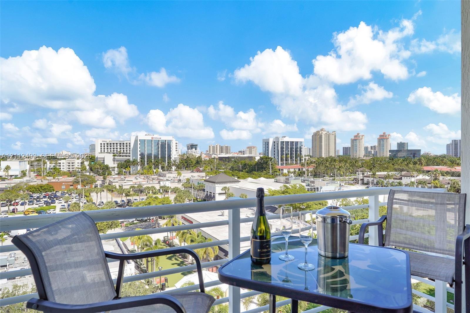 Private balcony featuring metal railings and an expansive urban horizon