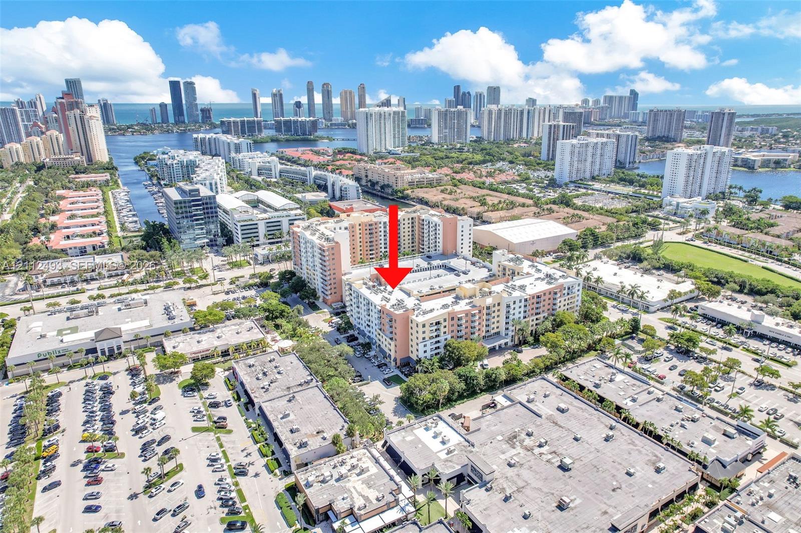 Aerial perspective of a multi-story residential building featuring a stucco exterior and flat roofline, positioned within a high-density urban environment Aerial perspective of a multi-story residential building featuring a stucco exterior and flat roofline, positioned within a high-density urban environment