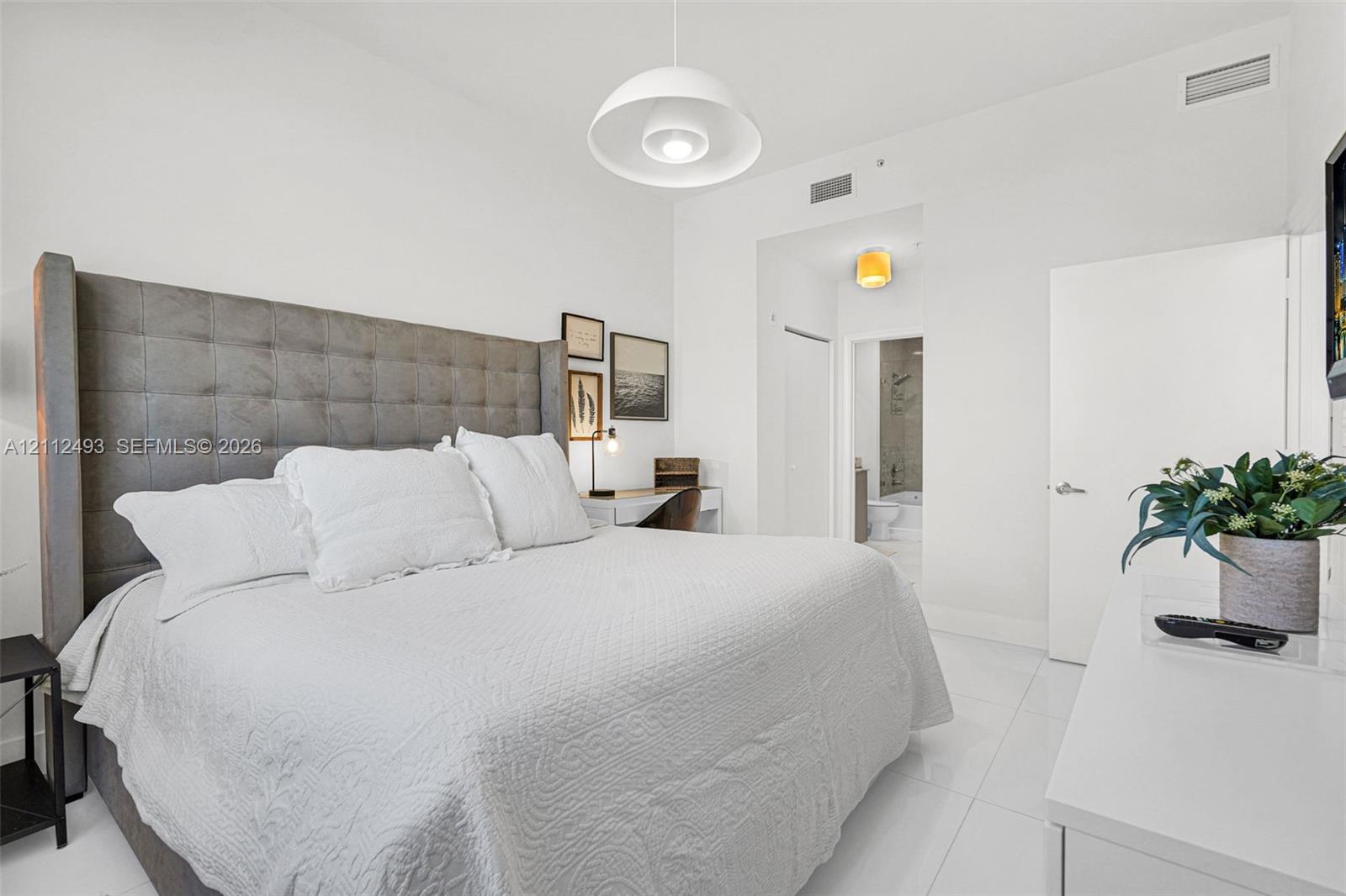 Polished tile flooring, minimalist white dome pendant lighting, and recessed ceiling illumination