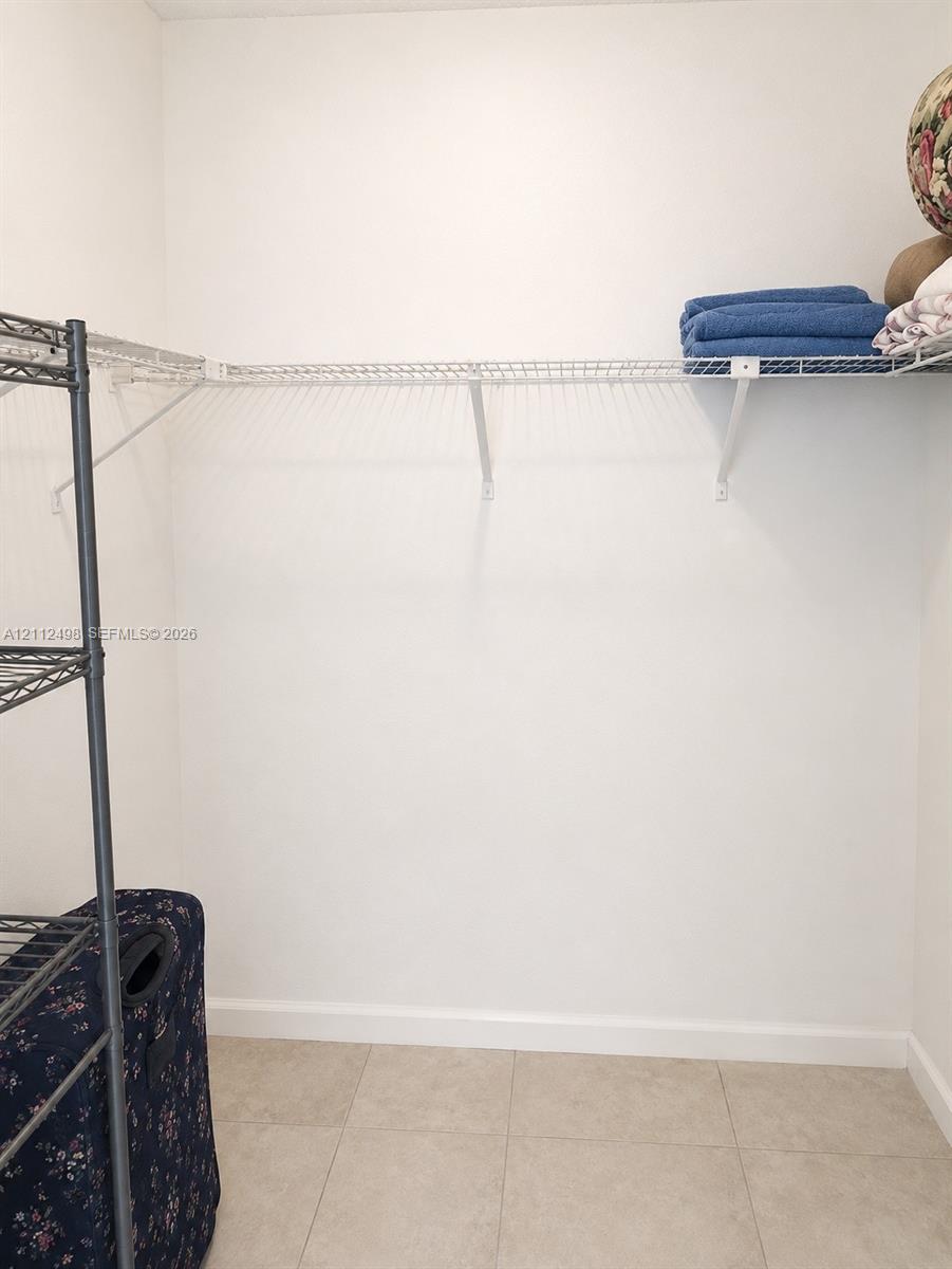 Storage area featuring wire shelving and neutral tile flooring