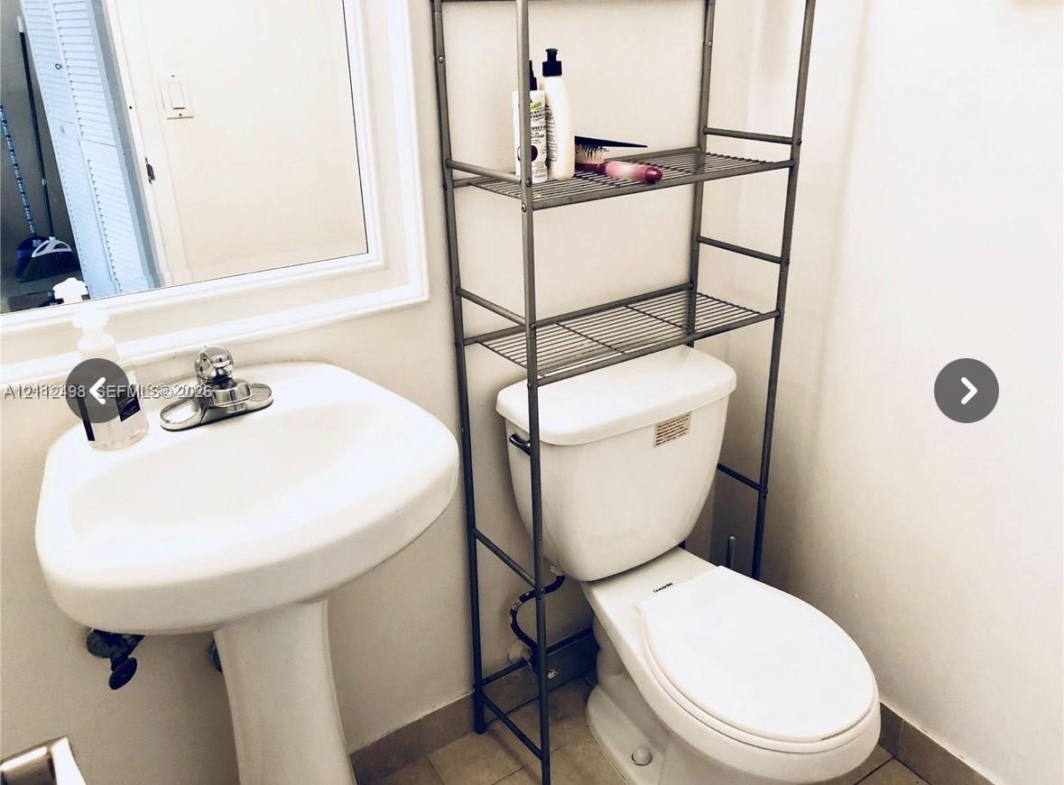 Pedestal sink with chrome dual-handle faucet and wall-mounted mirror